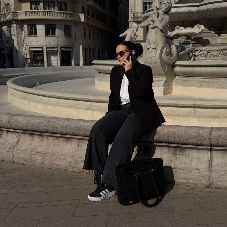 LAILI STUDIO femme au téléphone en ville avec un grand sac au crochet